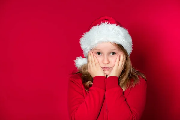 Lány Santa Claus Kalap Piros Pulóver Előtt Piros Háttér — Stock Fotó