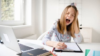 Kız evde internetten bilgisayar okuyup salgın sırasında karantina izolasyon sürecine bakıyor. Evde eğitim. Sosyal uzaklık. Çevrimiçi okul testi