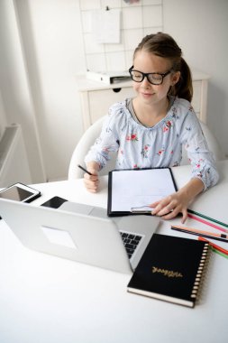 Liseli kız evde e-öğrenim ve video konferansı yapıyor.