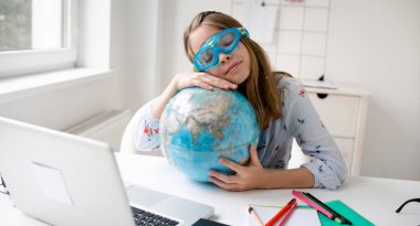 Şirin sarışın kız dizüstü bilgisayarının önünde oturmuş elinde küreyle dalgıç gözlükleri takıyor ya da yüzme gözlükleri takıyor ve tatille ilgili rüyalar görüyor ve karantina sona eriyor.