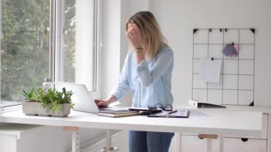 İş kadını dizüstü bilgisayar kullanıyor, ofiste çalışıyor.