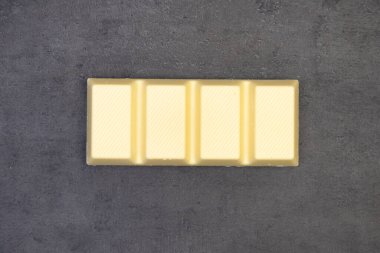 Koyu gri arka planda duran çikolata, yukarıdan çekilmiş bir fotoğraf.