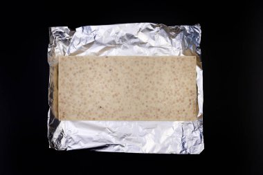 Gümüş folyo üzerine tatlı ve lezzetli çikolata. Yukarıdan çekilmiş siyah arka plan fotoğrafı.