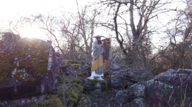 Sakallı Avrupalı bir adam doğada geleneksel Japon, Shugendo kıyafetleriyle meditasyon yapıyor.