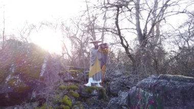 Sakallı Avrupalı bir adam doğada geleneksel Japon, Shugendo kıyafetleriyle meditasyon yapıyor.