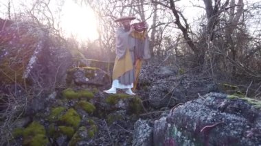 Sakallı Avrupalı bir adam doğada geleneksel Japon, Shugendo kıyafetleriyle meditasyon yapıyor.