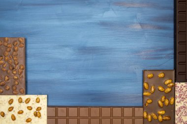 mavi arka planda farklı lezzetli çikolatalar.