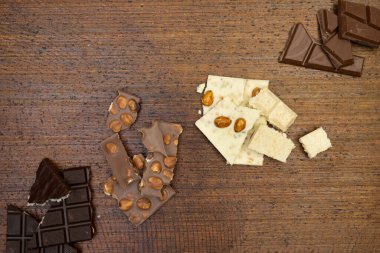 Kahverengi arka planda farklı çikolata türleri var. 