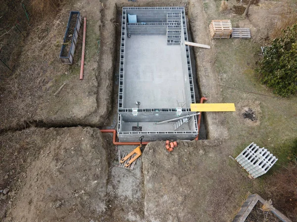 Drones aerial photo of a construction site of a pool, formwork concrete blocks already finished and bricked up with construction adhesive, steps already prepared and ready for concrete filling
