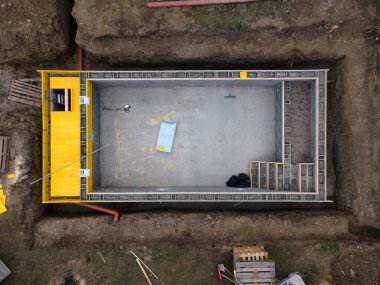 İnşaat alanının havuzdan havuzdan havadan drone görüntüsü beton ve bitmiş tuğla duvar resmi.