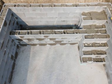 Havuz inşaatı alanının havadan drone görüntüsü, betonla doldurulmuş şekiller.