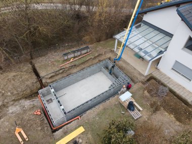 Havuz inşaatı alanının havadan drone görüntüsü, betonla doldurulmuş şekiller.