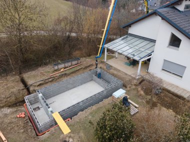 Havuz inşaatı alanının havadan drone görüntüsü, betonla doldurulmuş şekiller.