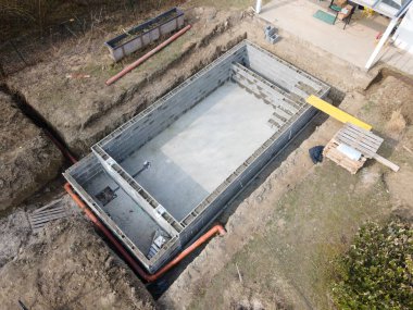 Havuz inşaatı alanının havadan drone görüntüsü, betonla doldurulmuş şekiller.