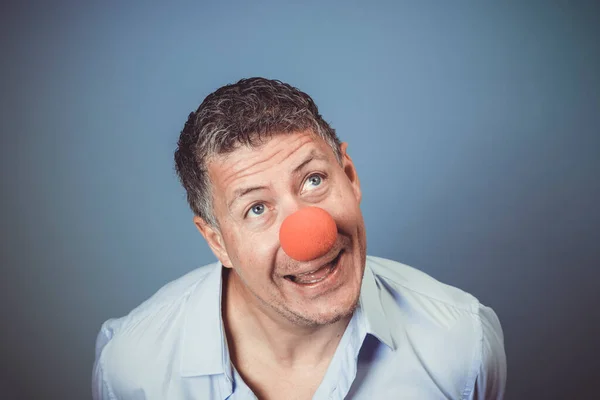 Medelålders Man Med Blå Skjorta Och Röd Clown Näsa Poserar — Stockfoto