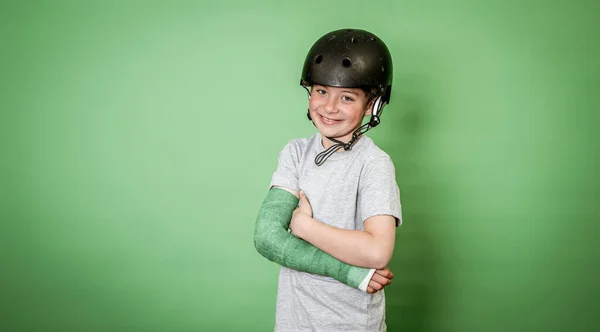 Крутой Храбрый Мальчик Сломанной Рукой Зеленой Кистью Позирует Студии Шлеме — стоковое фото