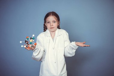 İki örgülü güzel kız bilim adamı gibi giyinmiş ve elinde mavi arka plandaki moleküllerin modelini tutuyor.