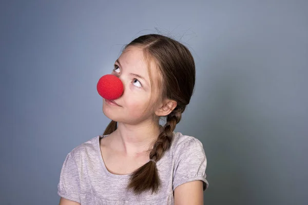 Graziosa Ragazza Con Naso Rosso Pagliaccio Due Trecce Camicia Grigia — Foto Stock