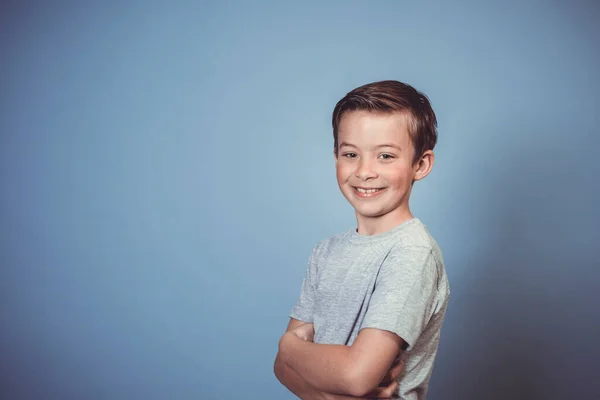 Hűvös Fiatal Fiú Szürke Póló Pózol Előtt Kék Háttér Stúdióban — Stock Fotó