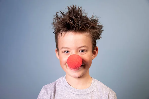 Крутий Хлопчик Диким Волоссям Позує Червоним Клоуном Синьому Фоні — стокове фото