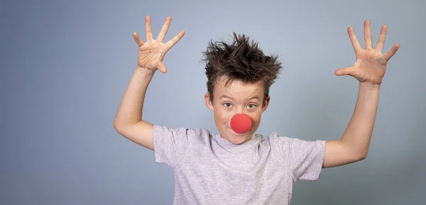 Крутий Хлопчик Диким Волоссям Позує Червоним Клоуном Синьому Фоні — стокове фото