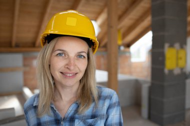 Sarı kasklı ve mavi gömlekli güzel bir bayan mimar portresi.