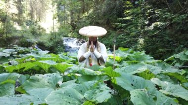 Sakallı Avrupalı bir adam geleneksel Japon Shugendo kıyafetiyle meditasyon yapıyor.