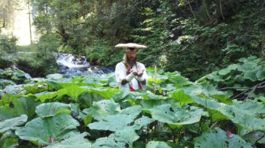 Sakallı Avrupalı bir adam geleneksel Japon Shugendo kıyafetiyle meditasyon yapıyor.