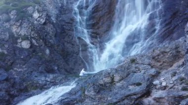 Geleneksel Japon shugendo kıyafeti giymiş bir adam kışın şelale meditasyonu yapıyor.