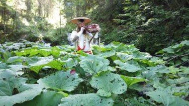 Sakallı Avrupalı bir adam doğada geleneksel Japon, Shugendo kıyafetleriyle meditasyon yapıyor.