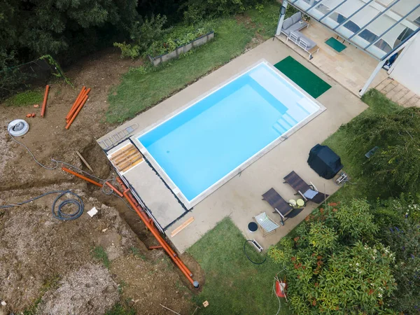 aerial drone flight of pool build construction site with pool filled with water