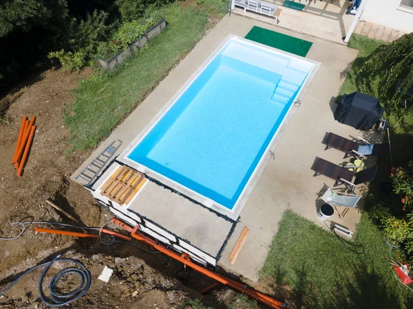 aerial drone flight of pool build construction site with pool filled with water