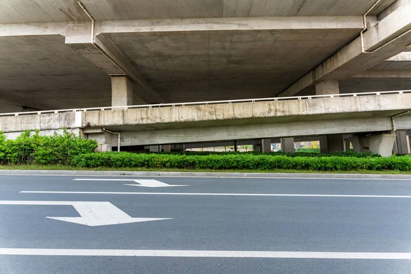 城市立交桥下的混凝土结构和沥青路面空间 — 图库照片