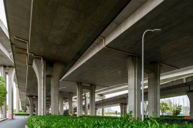 Şehirdeki üst geçidin altında beton yapı ve asfalt yol alanı