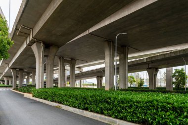 Şehirdeki üst geçidin altında beton yapı ve asfalt yol alanı