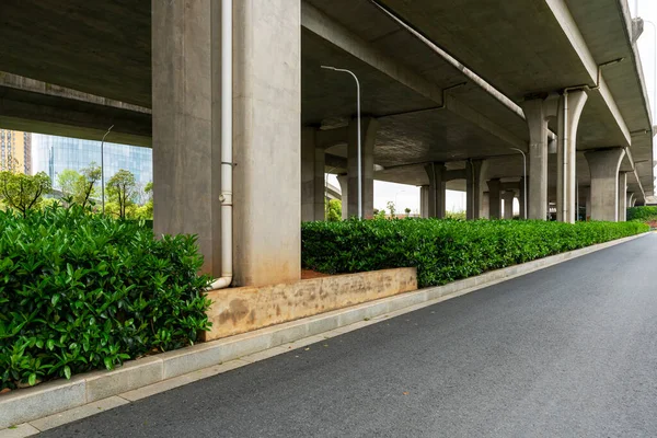 Şehirdeki üst geçidin altında beton yapı ve asfalt yol alanı
