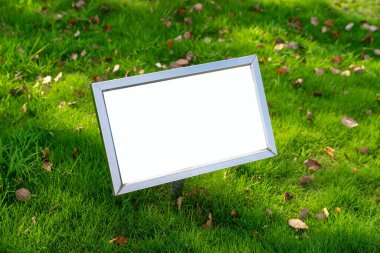 Çimlerin üzerinde duran reklam panosu