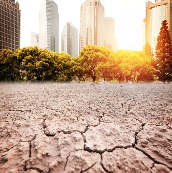 City looks over cracked earth landscape — Stock Photo, Image