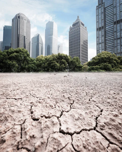 City looks over cracked earth landscape — Stock Photo, Image
