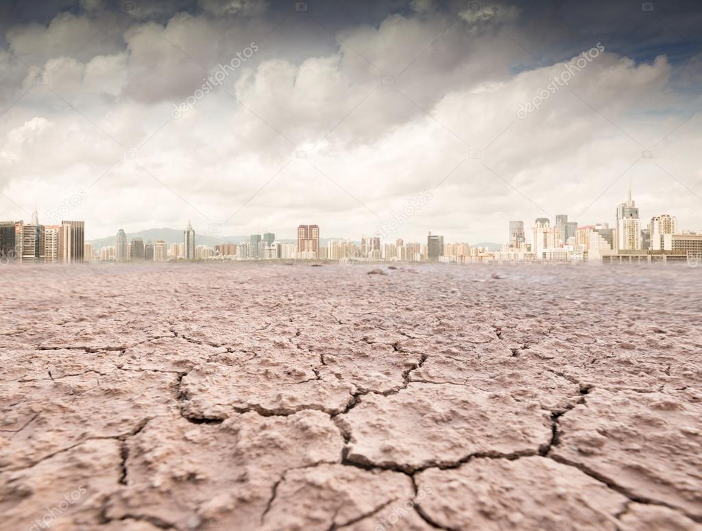 City looks over cracked earth landscape