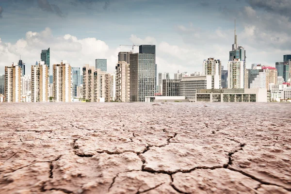 Ciudad mira sobre tierra agrietada paisaje —  Fotos de Stock