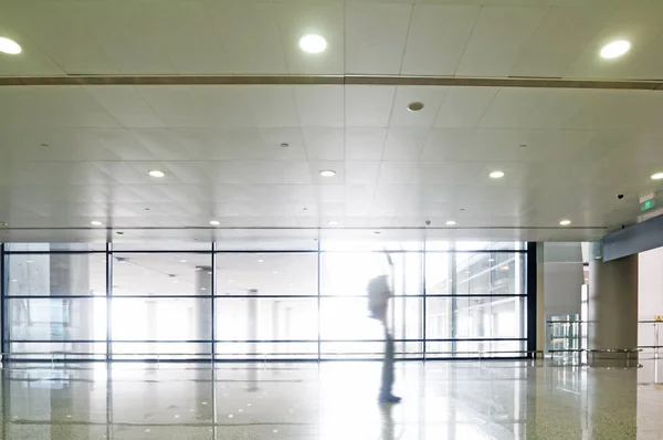 Silueta de la gente en el pasillo del edificio de oficinas — Foto de Stock