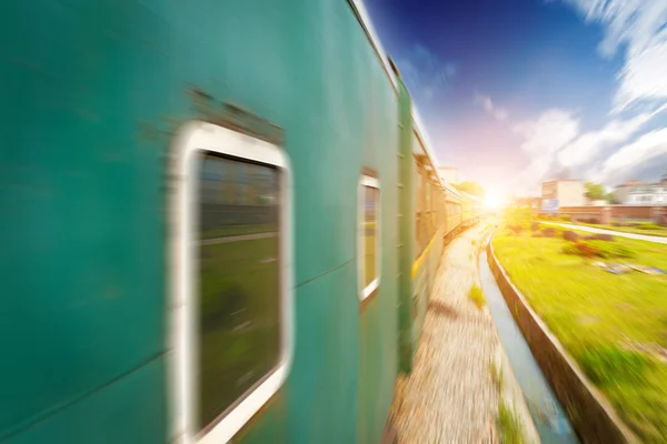 Tåg förbi i orange sunset — Stockfoto