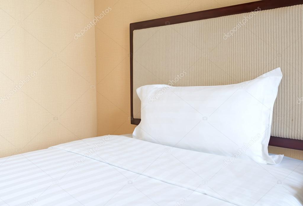 White pillow on wooden bed