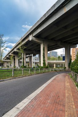 Şehirdeki üst geçidin altında beton yapı ve asfalt yol alanı