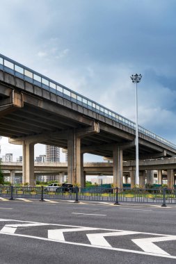 Şehirdeki üst geçidin altında beton yapı ve asfalt yol alanı