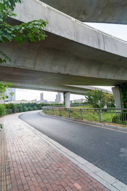 Şehirdeki üst geçidin altında beton yapı ve asfalt yol alanı