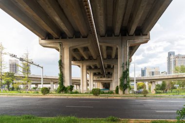 Şehirdeki üst geçidin altında beton yapı ve asfalt yol alanı