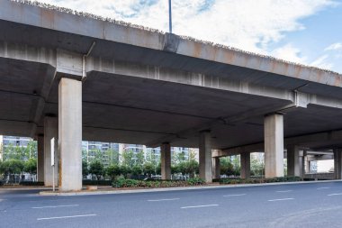 Şehirdeki üst geçidin altında beton yapı ve asfalt yol alanı