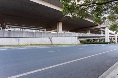 Şehirdeki üst geçidin altında beton yapı ve asfalt yol alanı